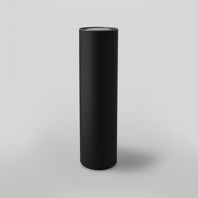 Black cylindrical candle packaging on a light grey background