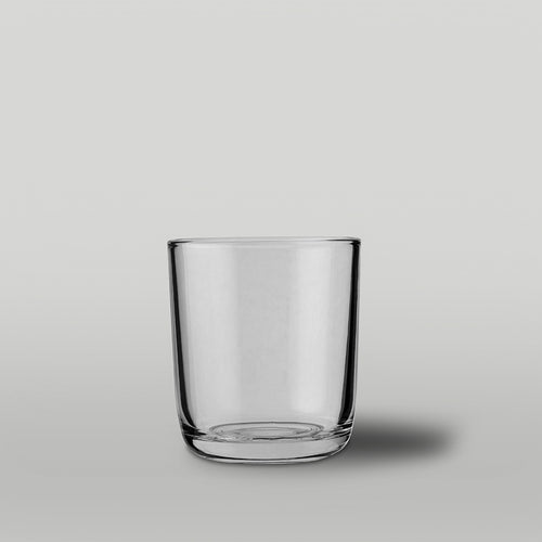 Clear glass candle jar on a gray background