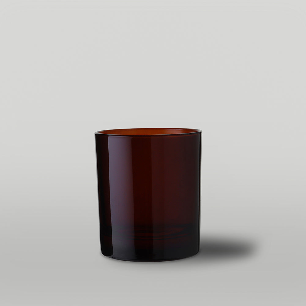 Amber candle glass on a light gray background
