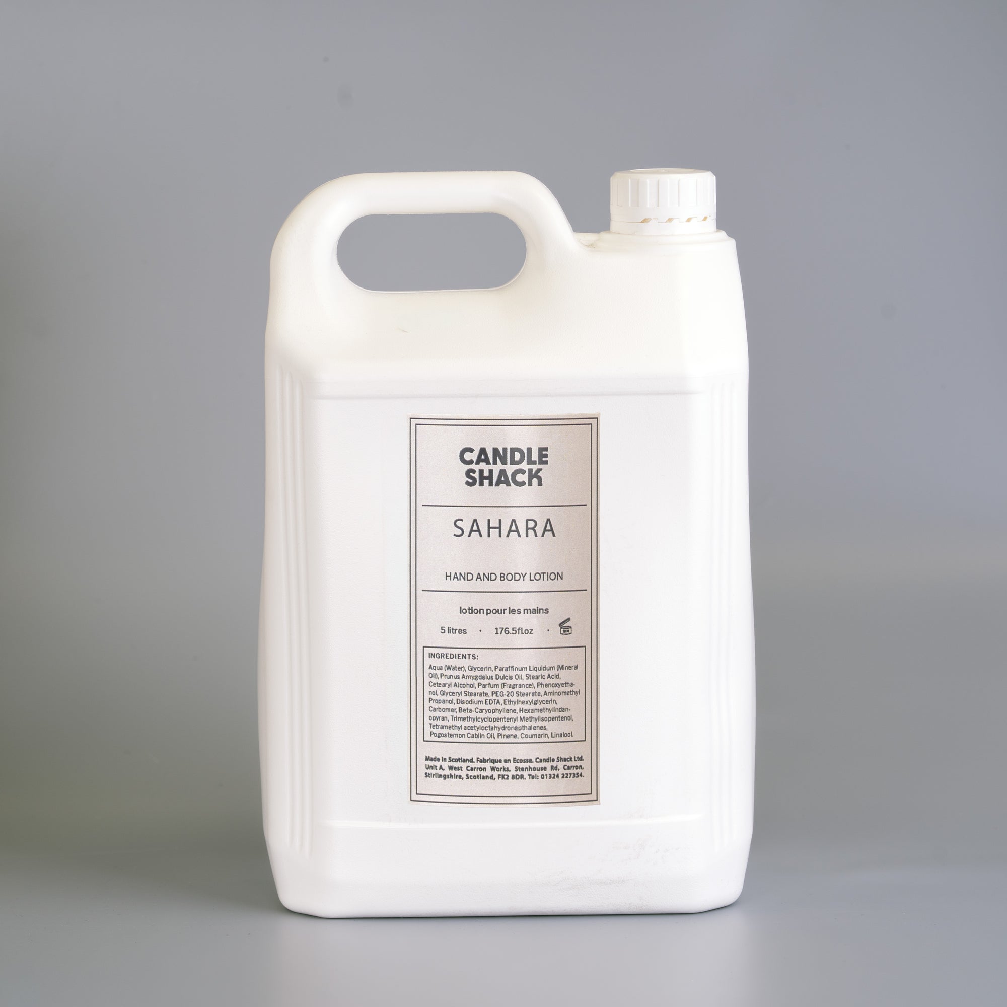 Large white container of Sahara hand and body lotion from Candle Shack on a gray background