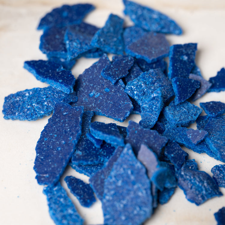 Closeup shot of blue dye chips. Dye for candle making. Candle dye. Coloured candles.