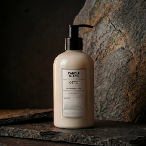 Lotion bottle labeled 'Candle Shack Luna' on a stone surface with a dark background