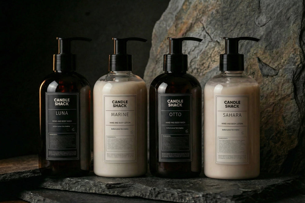 Four bottles of  soCandle Shack soap and lotion on a stone surface with a dark background