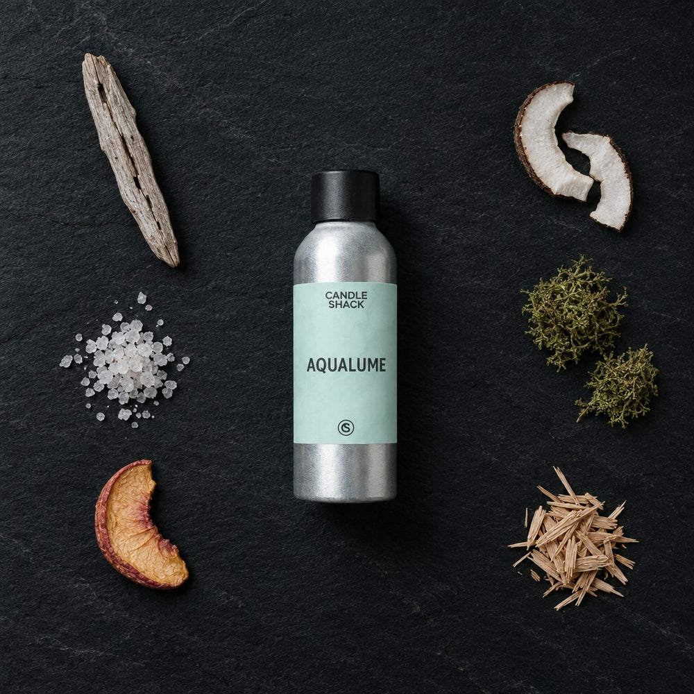 AquaLume fragrance oil - Candle Shack aluminium bottle with dried botanicals on a dark slate background