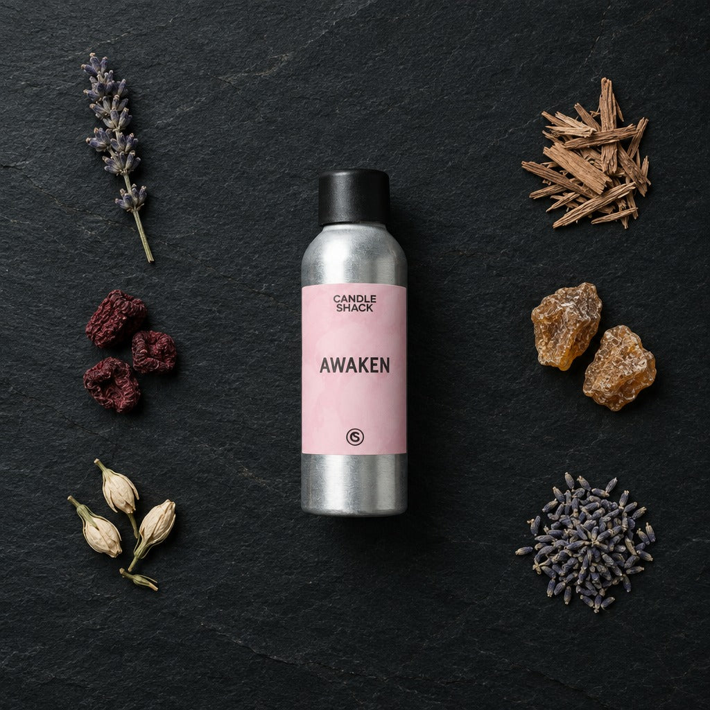 Awaken fragrance oil - Candle Shack aluminium bottle with dried botanicals on a dark slate background
