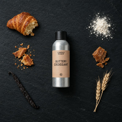 Buttery Croissant fragrance oil - Candle Shack aluminium bottle with dried botanicals on a dark slate background