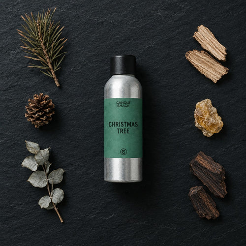 Christmas Tree fragrance oil - Candle Shack aluminium bottle with dried botanicals on a dark slate background