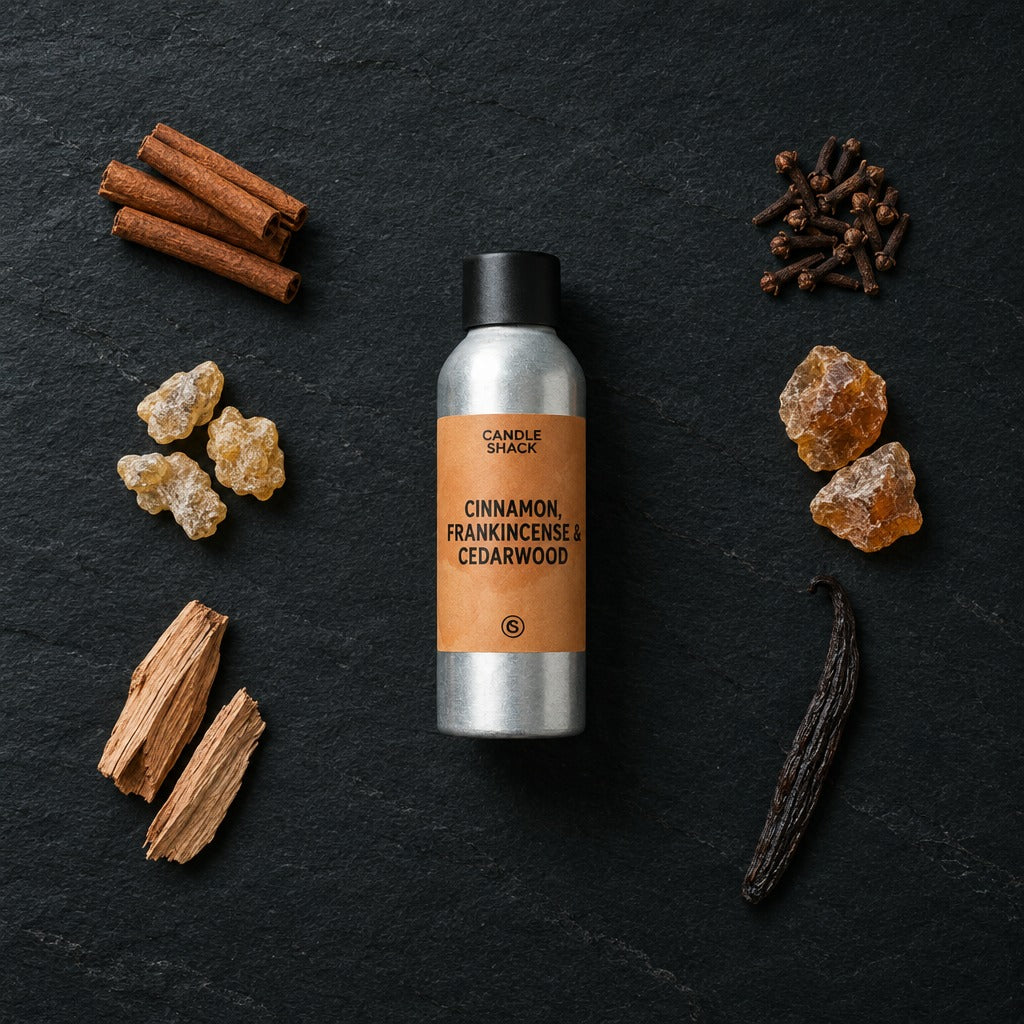Cinnamon, Frankincense & Cedarwood fragrance oil - Candle Shack aluminium bottle with dried botanicals on a dark slate background