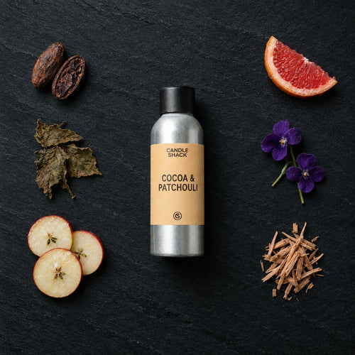 Cocoa & Patchouli fragrance oil - Candle Shack aluminium bottle with dried botanicals on a dark slate background
