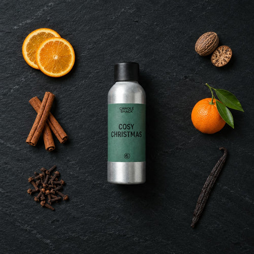 Cosy Christmas fragrance oil - Candle Shack aluminium bottle with dried botanicals on a dark slate background