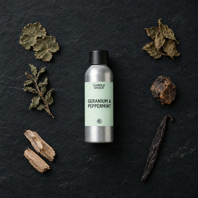Geranium & Peppermint with Citrepel Insect Repellent fragrance oil - Candle Shack aluminium bottle with dried botanicals on a dark slate background