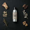 Himalayan Cedar & Jasmine fragrance oil - Candle Shack aluminium bottle with dried botanicals on a dark slate background
