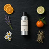 Invigorating Natural Oil fragrance oil - Candle Shack aluminium bottle with dried botanicals on a dark slate background
