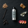 Midnight Amber fragrance oil - Candle Shack aluminium bottle with dried botanicals on a dark slate background