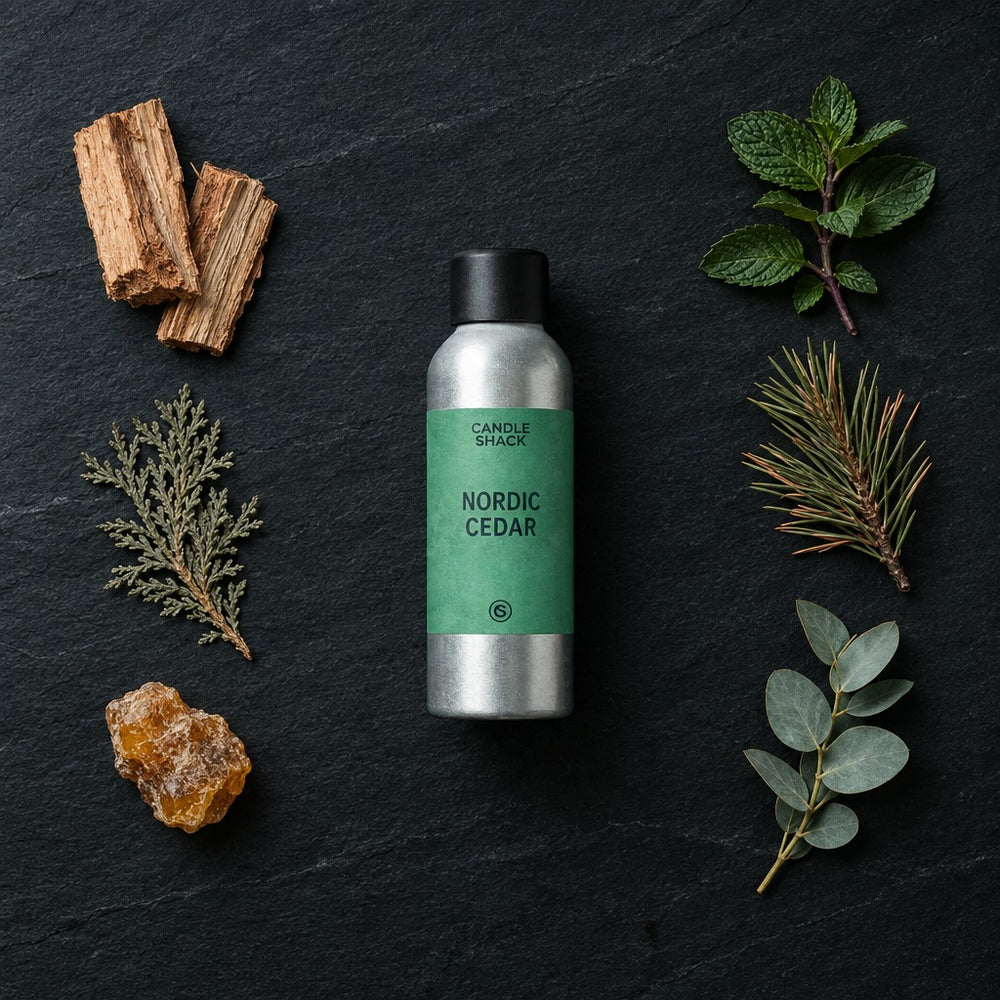 Nordic Cedar fragrance oil - Candle Shack aluminium bottle with dried botanicals on a dark slate background