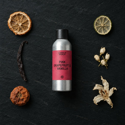 Pink Grapefruit and Vanilla fragrance oil - Candle Shack aluminium bottle with dried botanicals on a dark slate background