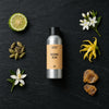 Rising Sun fragrance oil - Candle Shack aluminium bottle with dried botanicals on a dark slate background