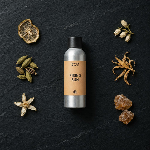 Rising Sun fragrance oil - Candle Shack aluminium bottle with dried botanicals on a dark slate background