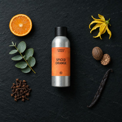 Spiced Orange fragrance oil - Candle Shack aluminium bottle with dried botanicals on a dark slate background