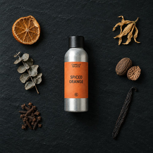 Spiced Orange fragrance oil - Candle Shack aluminium bottle with dried botanicals on a dark slate background