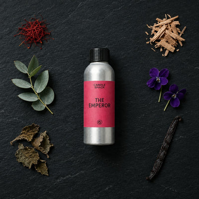The Emperor fragrance oil - Candle Shack aluminium bottle with dried botanicals on a dark slate background