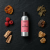 The Temptress fragrance oil - Candle Shack aluminium bottle with dried botanicals on a dark slate background