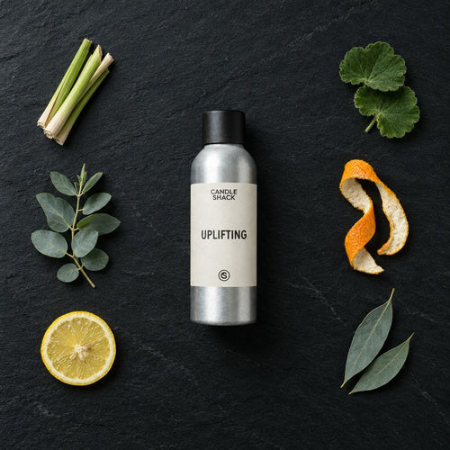 Uplifting Natural Oil fragrance oil - Candle Shack aluminium bottle with dried botanicals on a dark slate background
