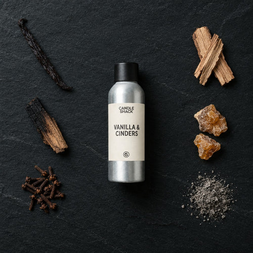 Vanilla & Cinders fragrance oil - Candle Shack aluminium bottle with dried botanicals on a dark slate background