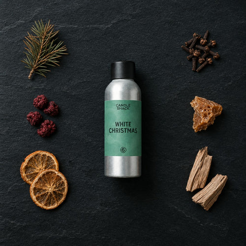 White Christmas fragrance oil - Candle Shack aluminium bottle with dried botanicals on a dark slate background