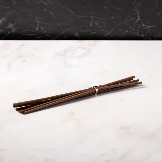 brown diffuser reeds on a marble surface