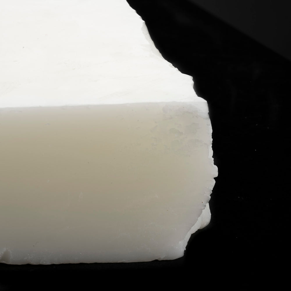 Close-up of a white wax block with a dark background