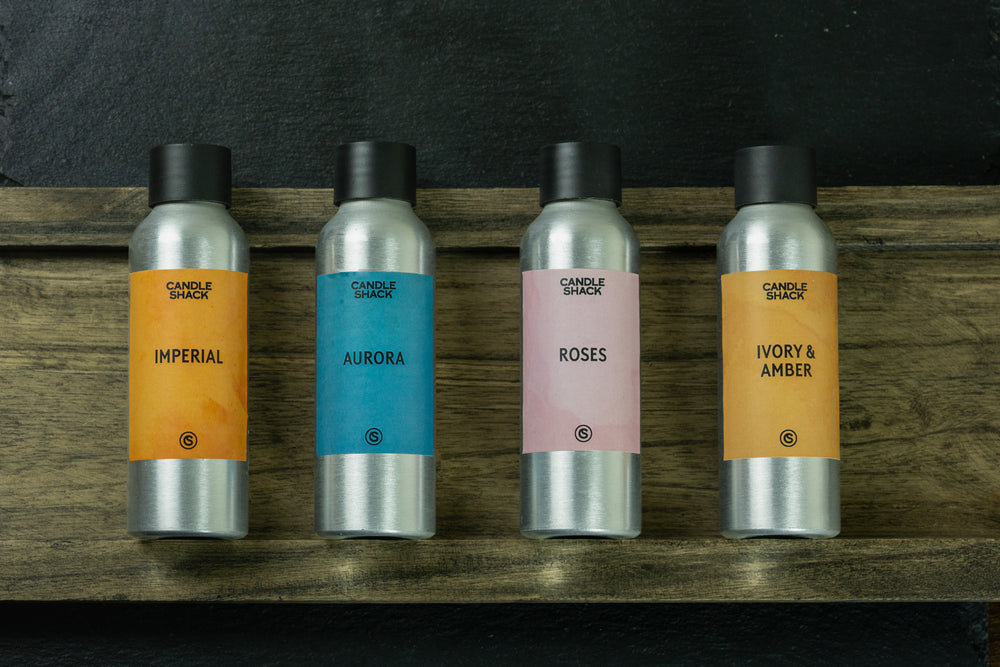 Four spring fragrance oil bottles with labels on a wooden surface